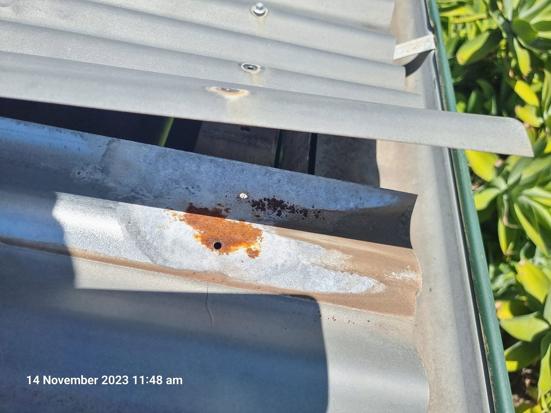 Rusty Metal Roof Seam With Peeling Paint and Water Damage Near a Gutter — Stormguard Roofing In Caloundra West, QLD