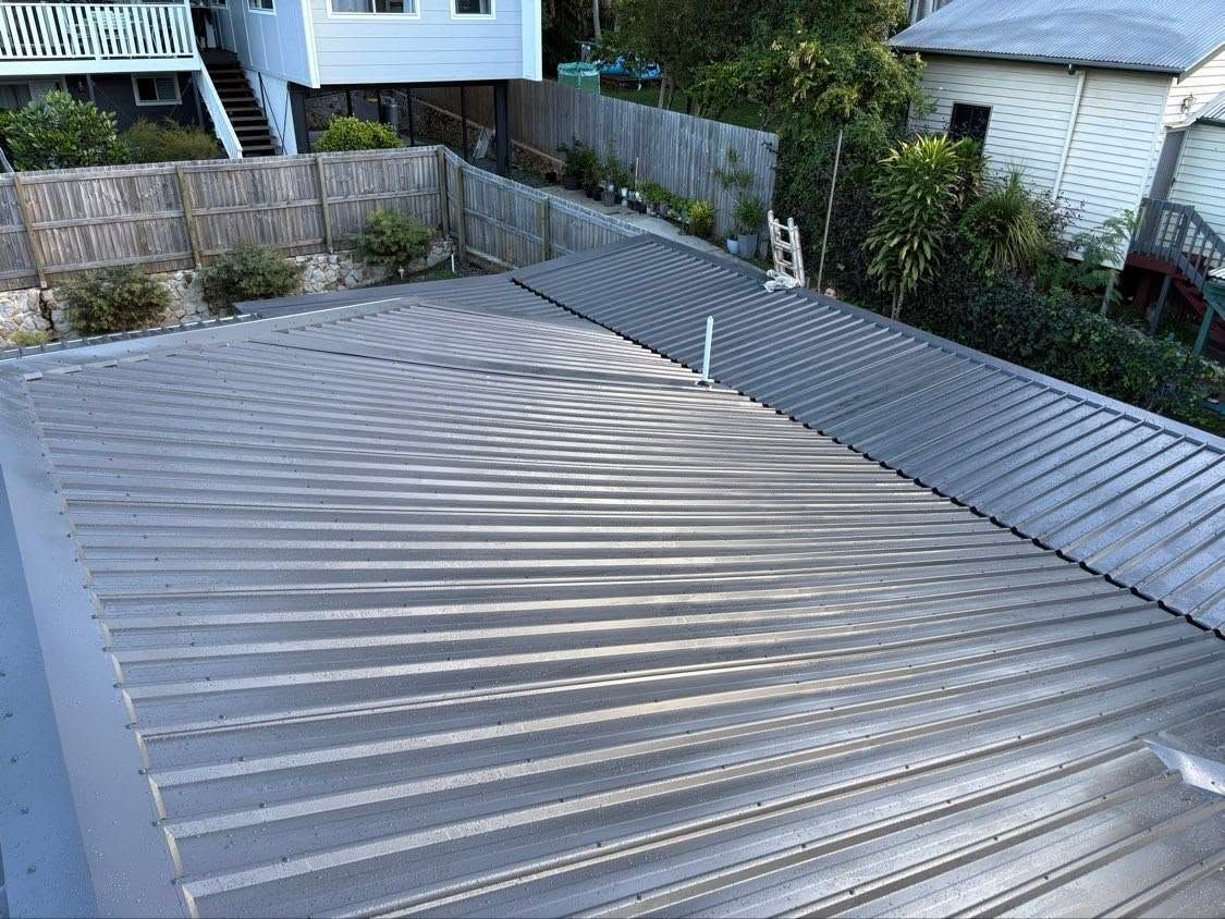 Roof With Gray Corrugated Metal Panels in a Residential Backyard — Stormguard Roofing In Caloundra West, QLD