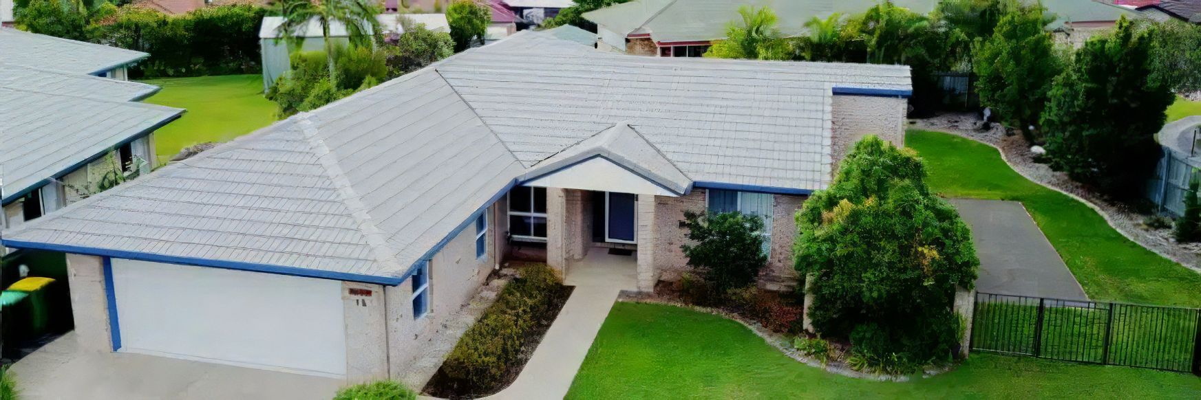 An Aerial View of a House With a Blue Roof in a Residential Area — Stormguard Roofing In Caloundra West, QLD