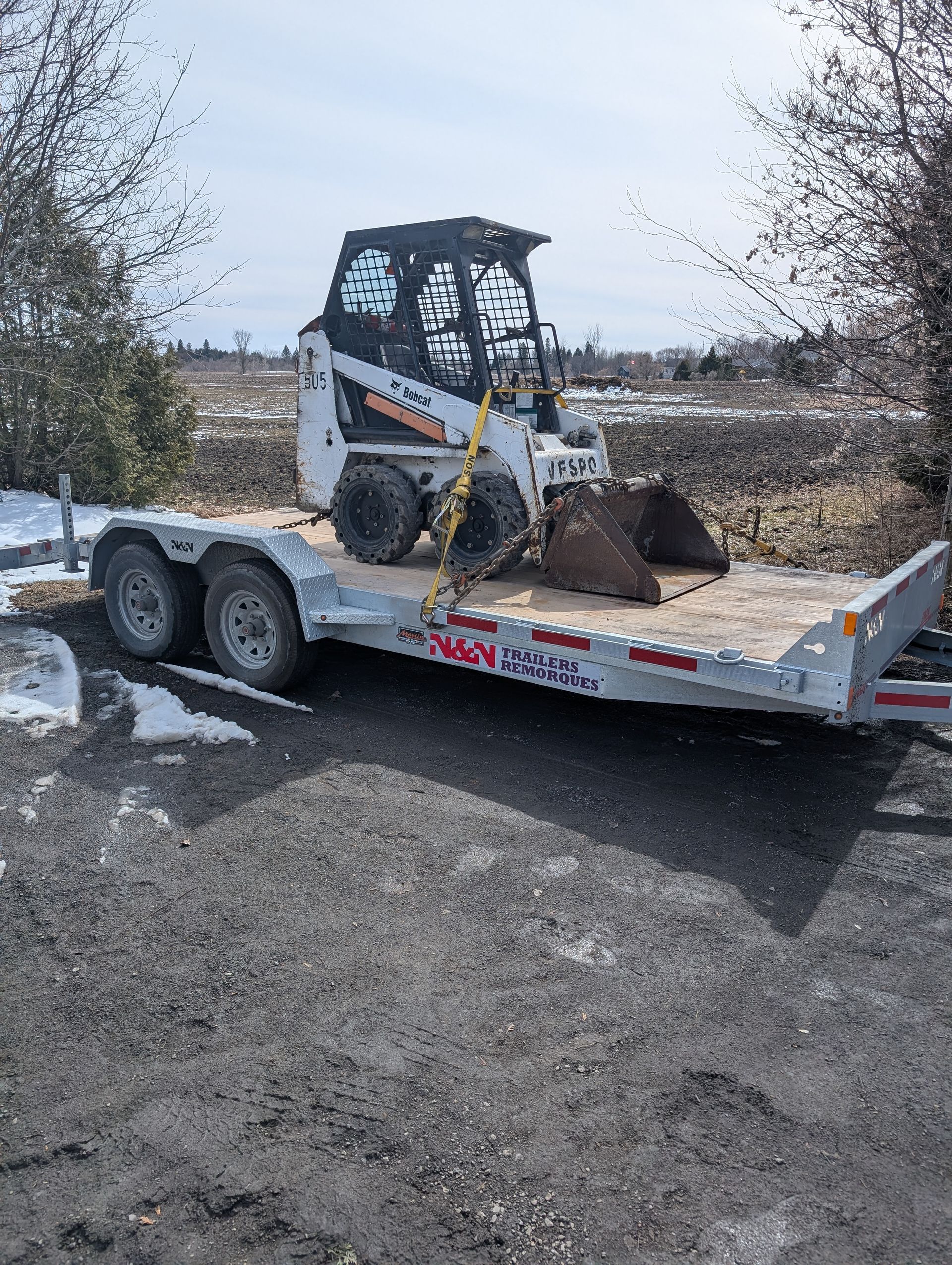 Un bulldozer est assis sur une remorque.
