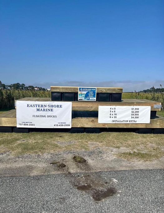 A sign for eastern shore marine is sitting on the side of a road.