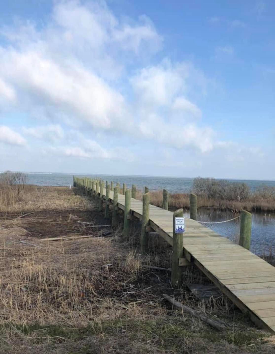 A wooden walkway leading to a body of water.