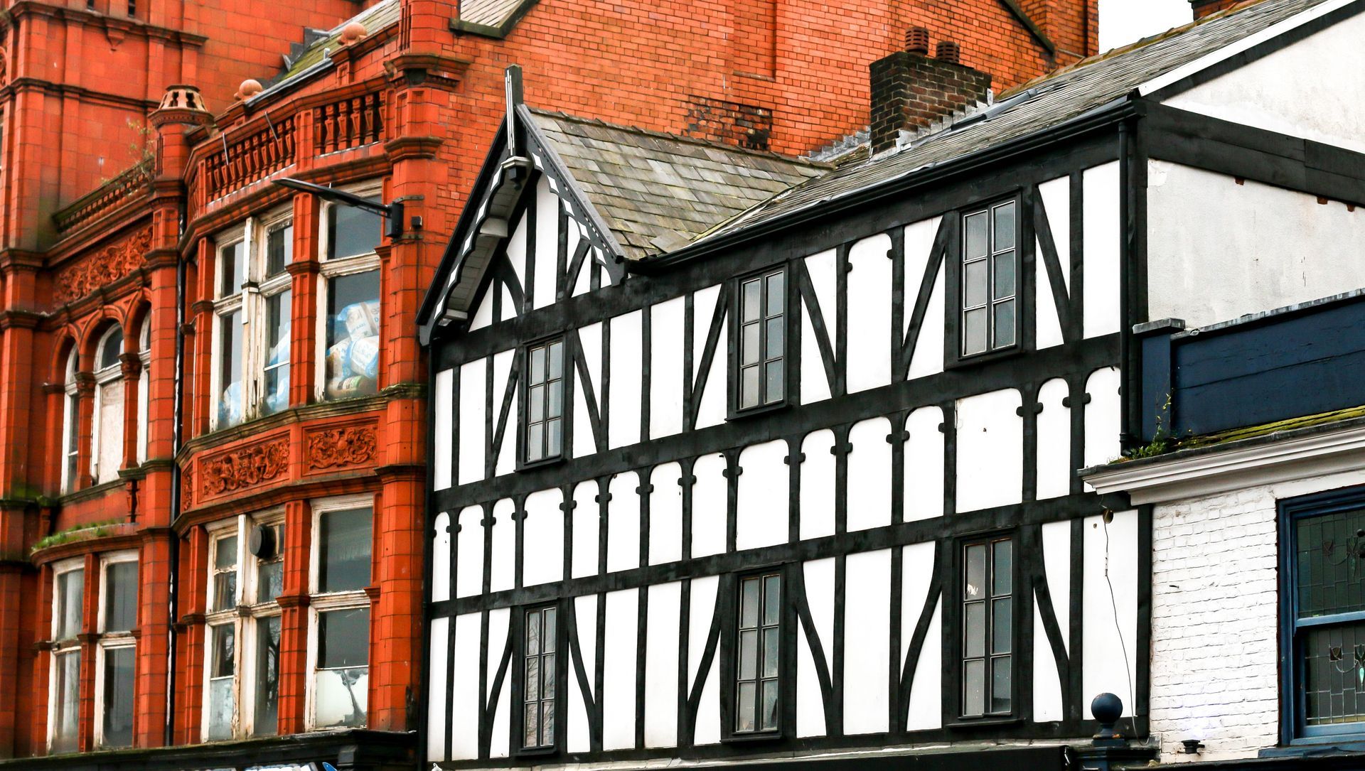 A black and white building with a brick building in the background.