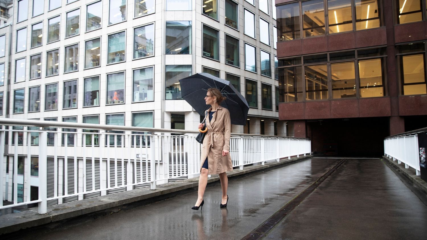 A woman is walking in the rain with an umbrella.