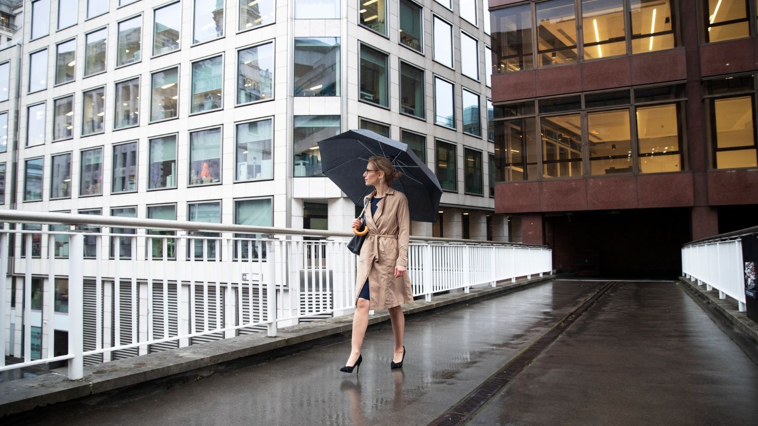 A woman is walking in the rain with an umbrella.