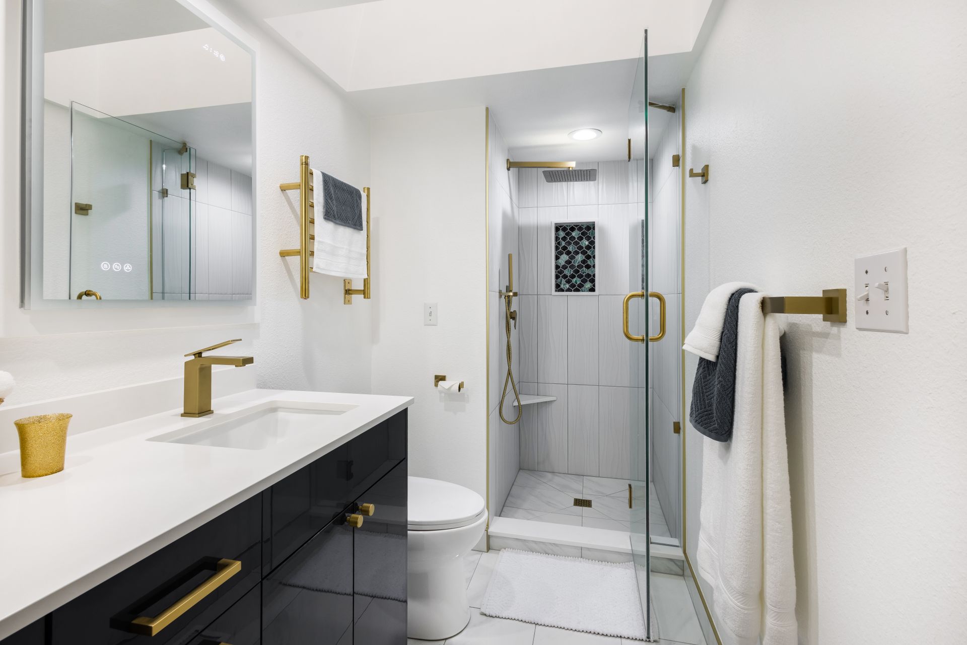 A bathroom with a toilet , sink , mirror and walk in shower.