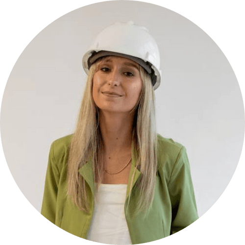 A woman wearing a hard hat and a green jacket is standing in a circle.