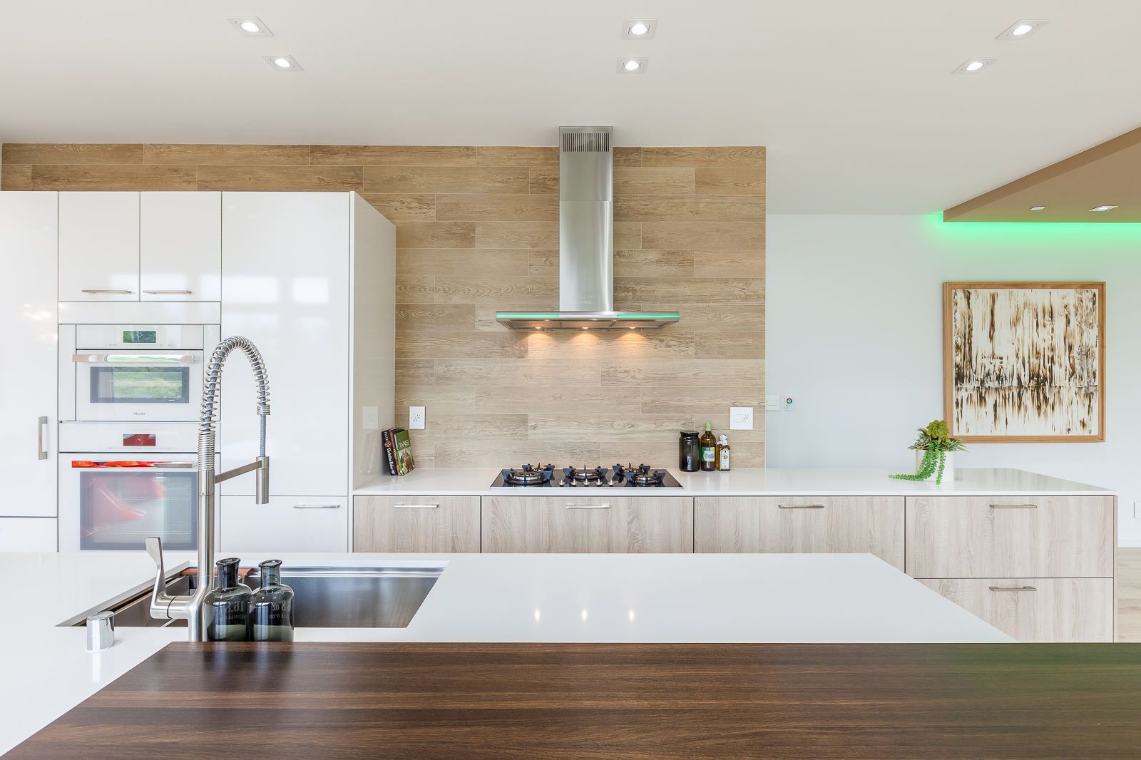 A kitchen with white cabinets , a sink , and a stove.