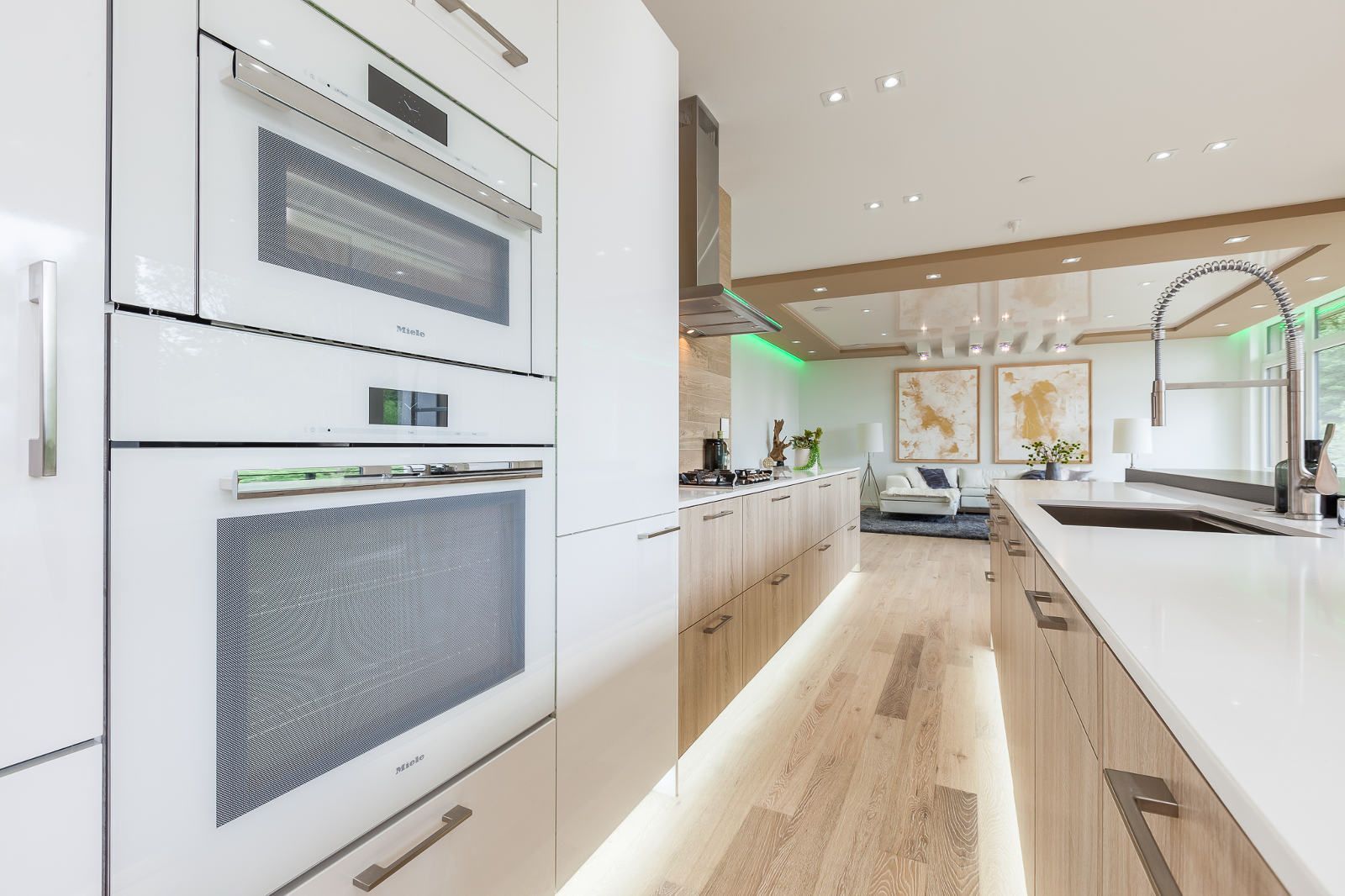 A kitchen with white cabinets , a sink , and a microwave oven.
