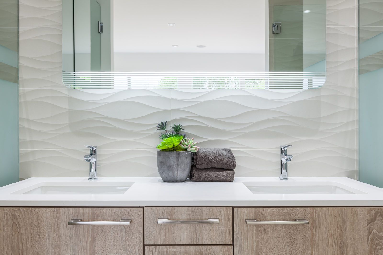 A bathroom with two sinks and a mirror.