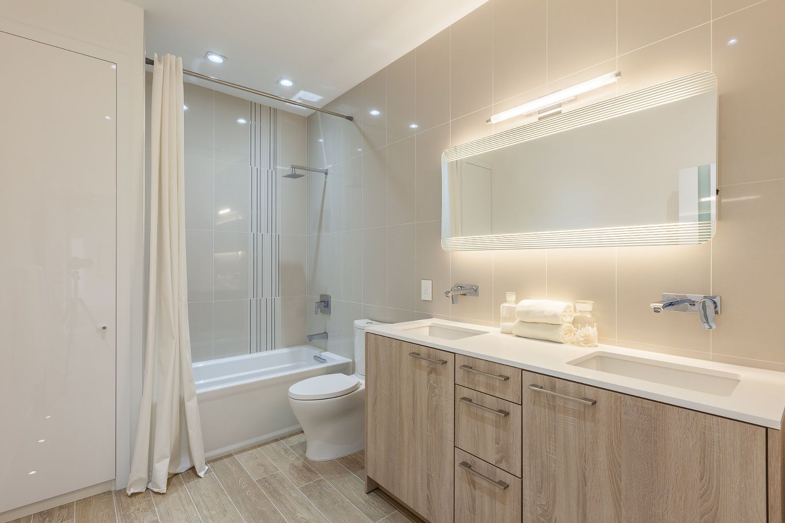 A bathroom with two sinks , a toilet , and a bathtub.