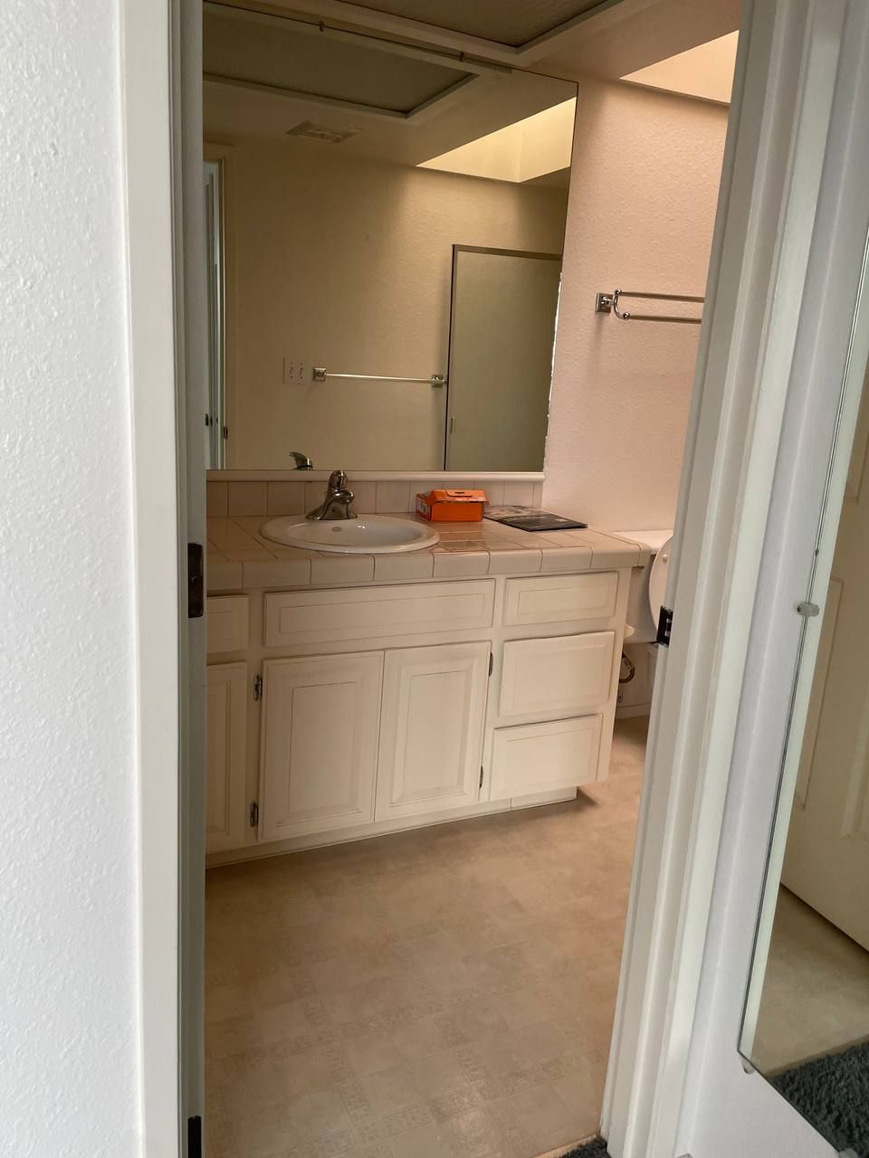 A bathroom with two sinks , a toilet and a mirror.