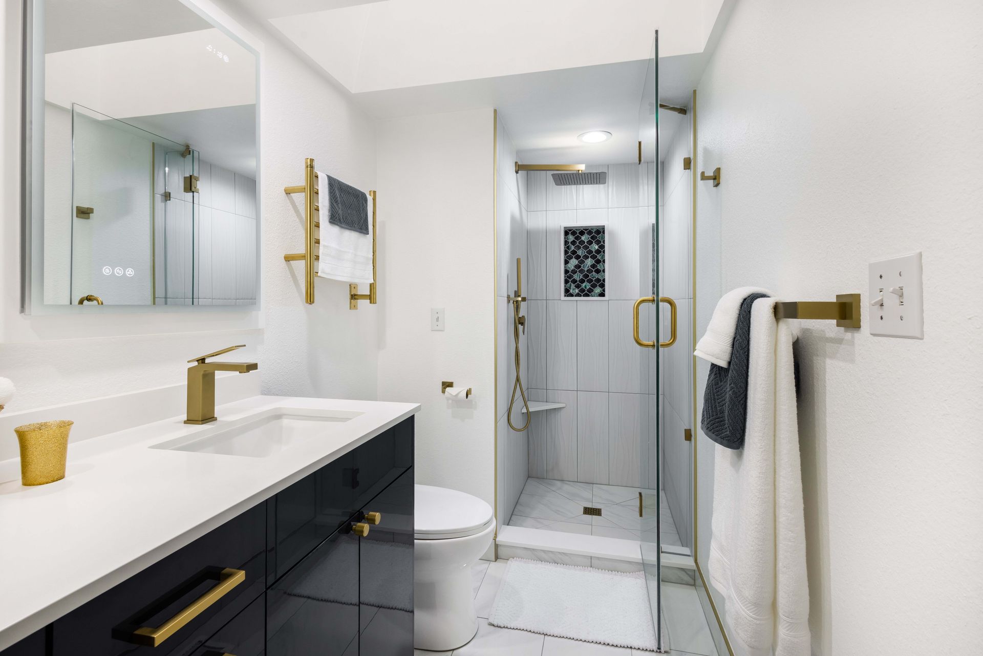 A bathroom with a toilet , sink , mirror and walk in shower.