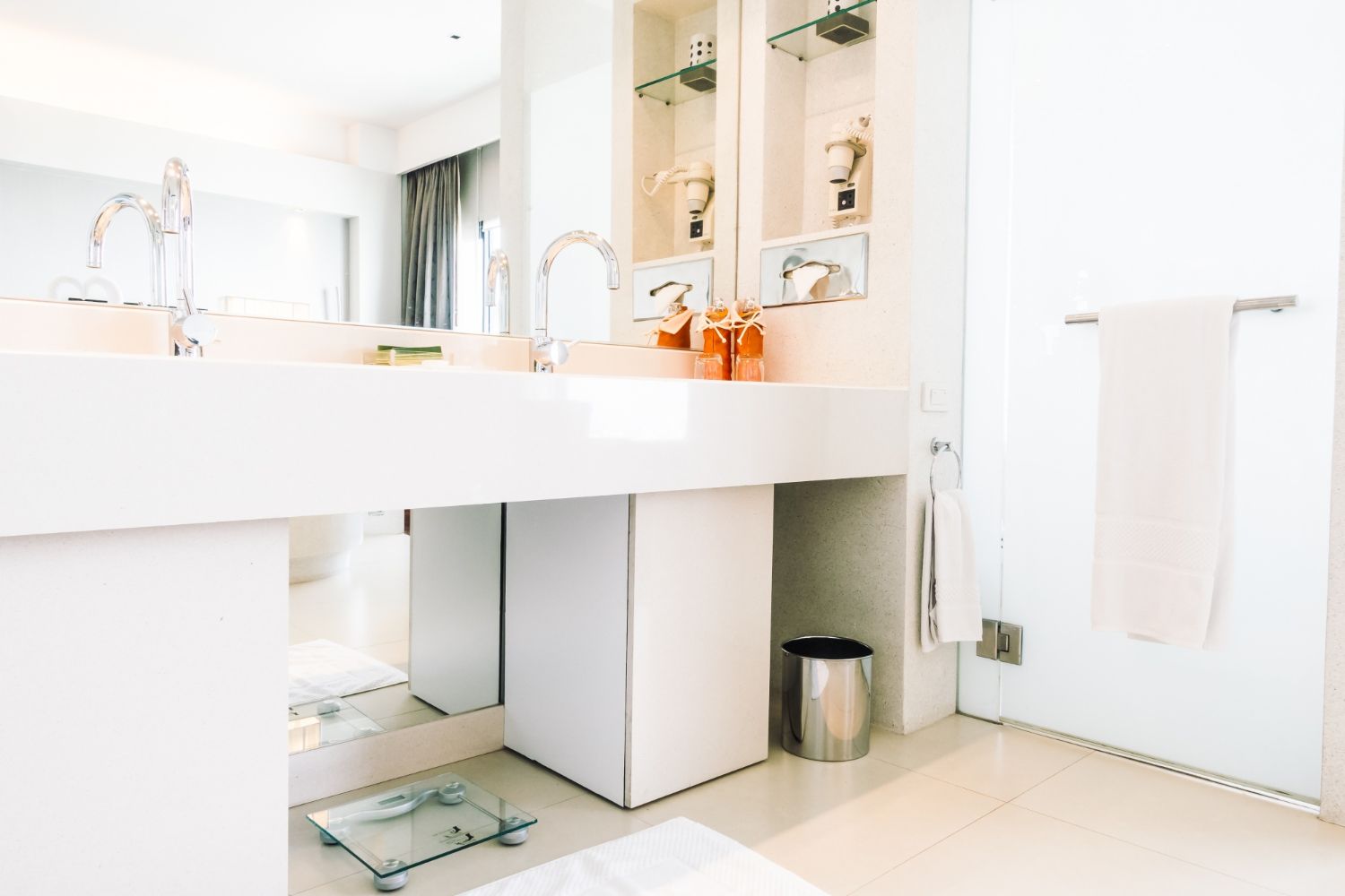 A bathroom with a sink , mirror and scale.