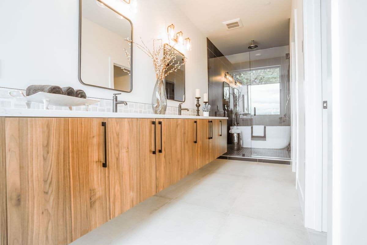 A bathroom with two sinks , a tub and a mirror.