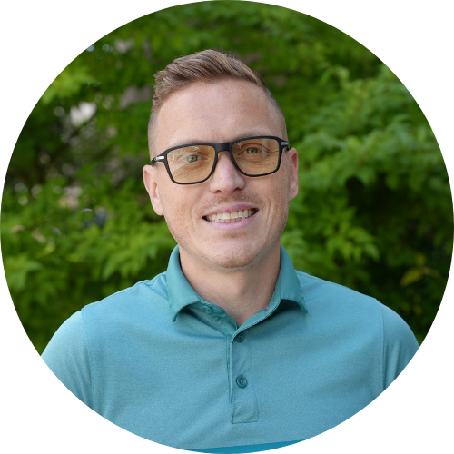 A man wearing glasses and a blue shirt is smiling in a circle.