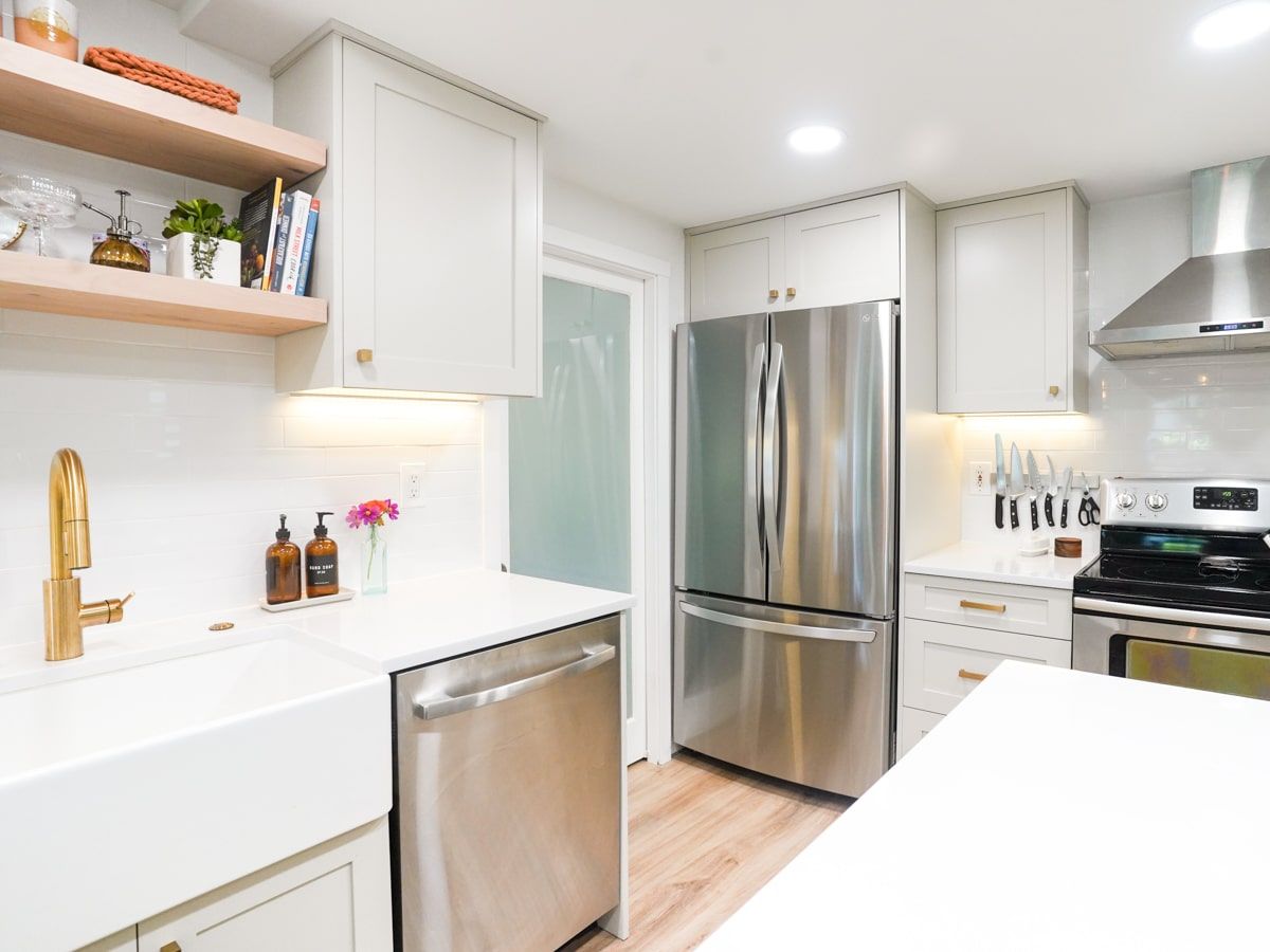 A kitchen with stainless steel appliances and white cabinets.