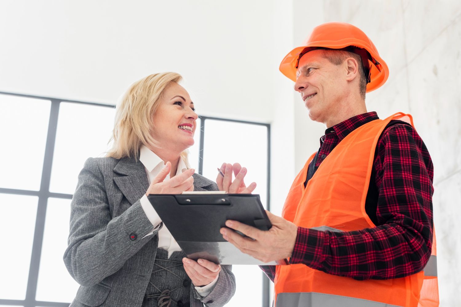 A man and a woman are looking at a clipboard.