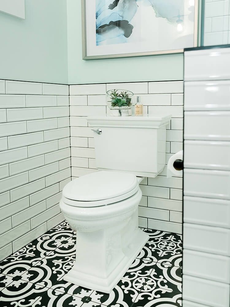 A bathroom with a toilet and a picture on the wall