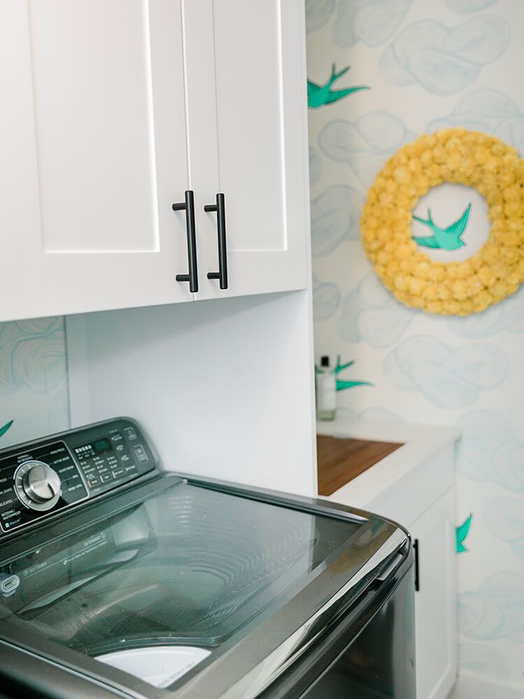 A laundry room with a washer and dryer and a wreath on the wall