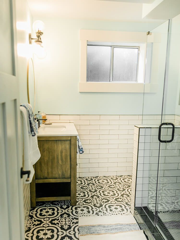 A bathroom with a sink , mirror , and walk in shower.