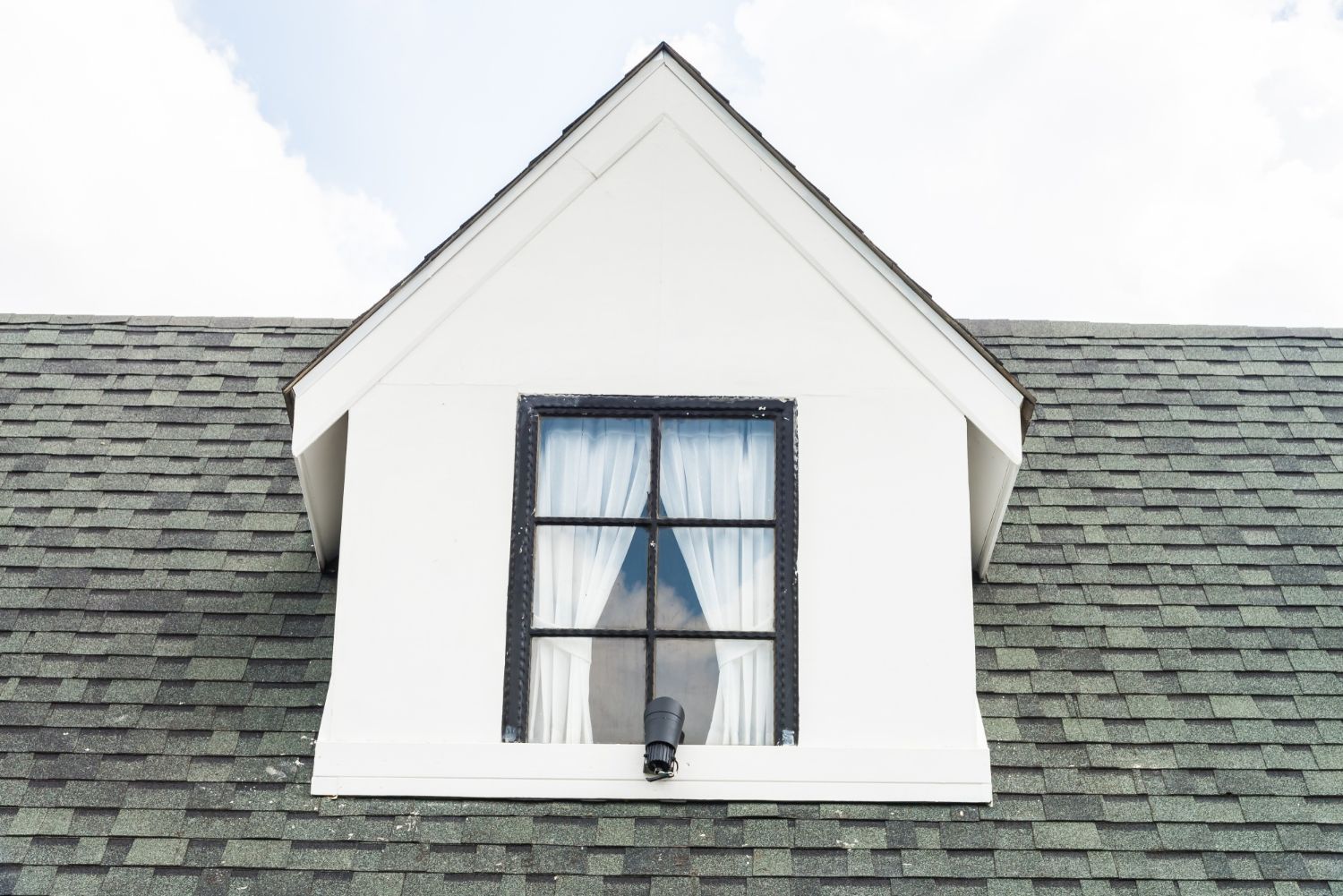 A white house with a window on the roof.