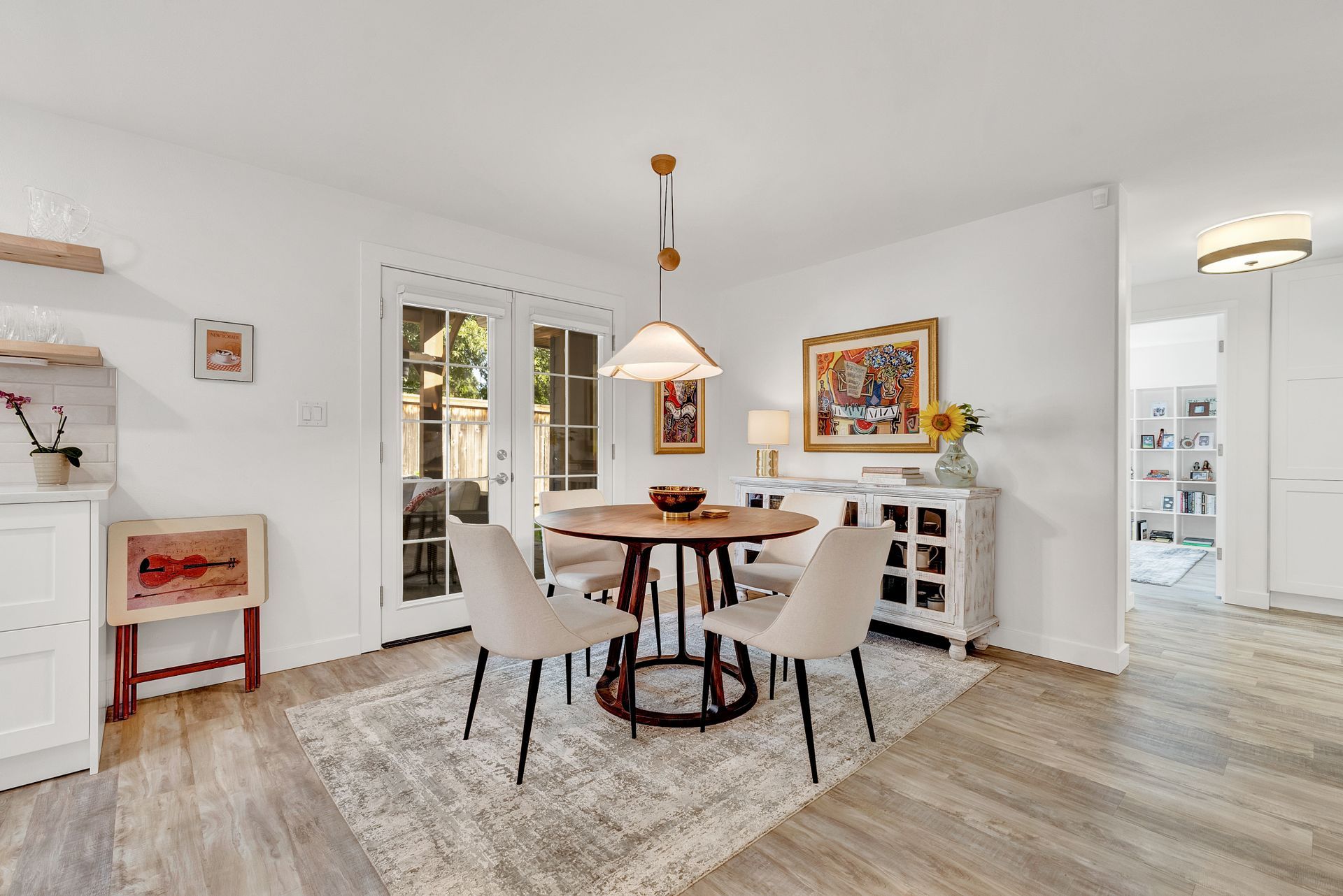 A dining room with a table and chairs and a rug.