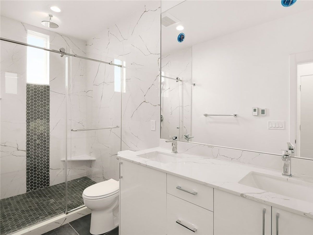 A bathroom with a toilet , sink , and shower.