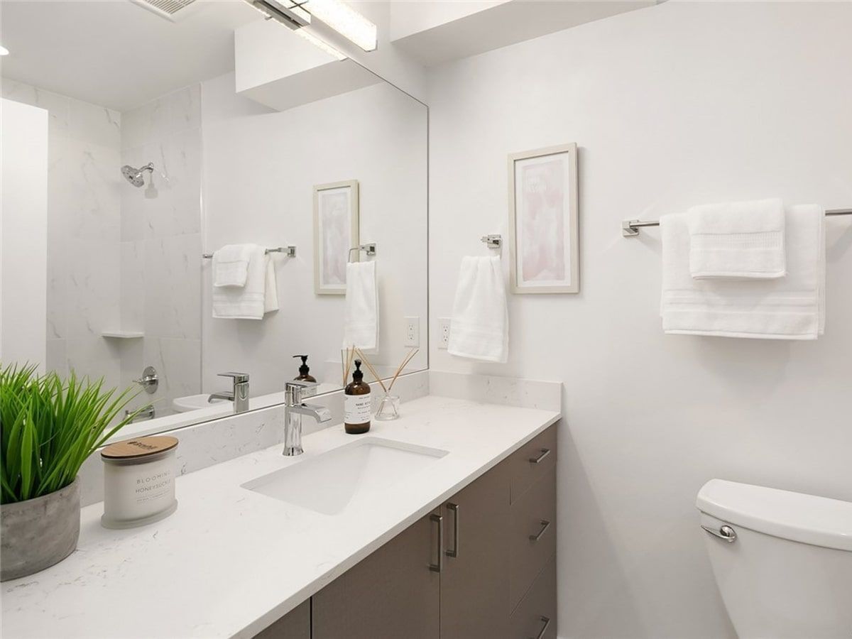 A bathroom with a sink , toilet and mirror.