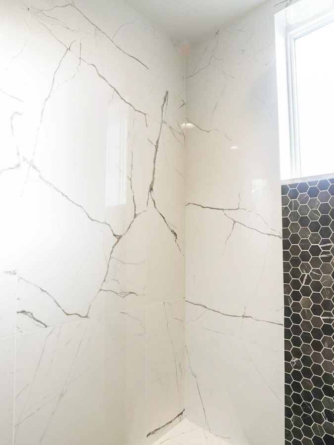A bathroom with a walk in shower and a window.
