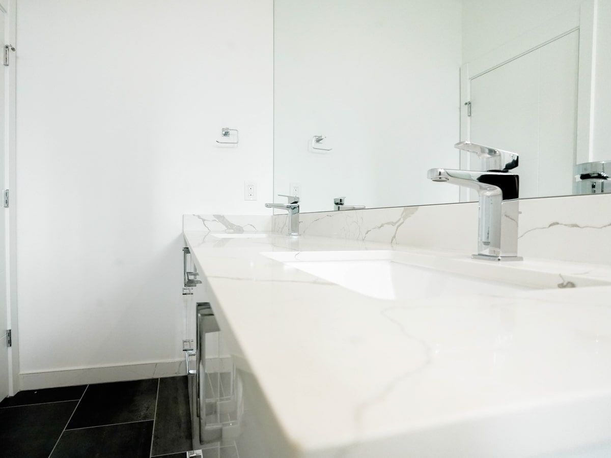 A bathroom with a sink , mirror and faucet.
