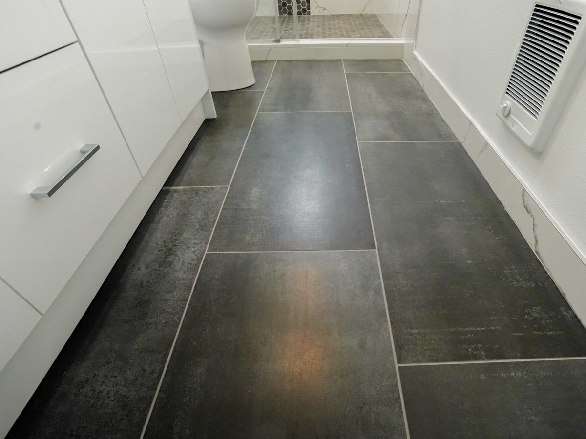 A bathroom with black tile floors and white cabinets