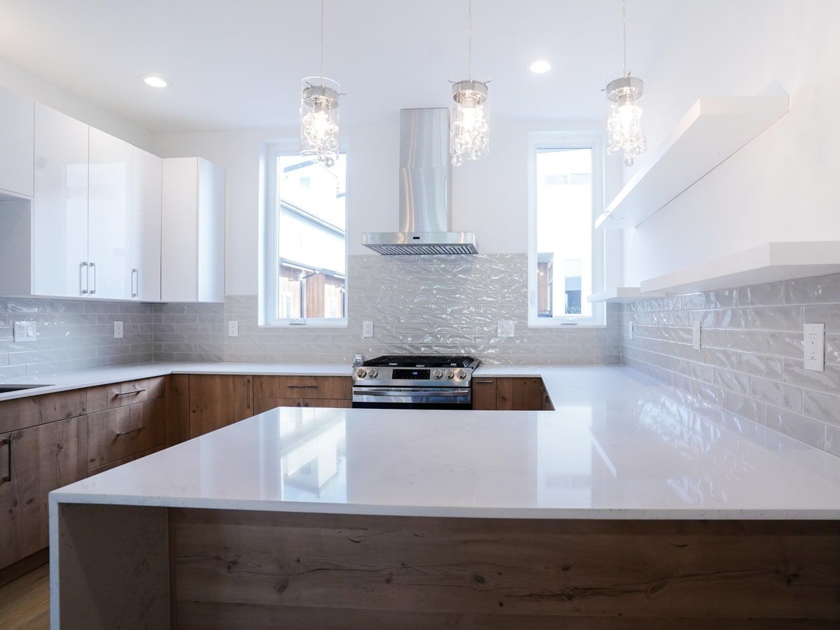 A kitchen with white cabinets and a stove top oven.