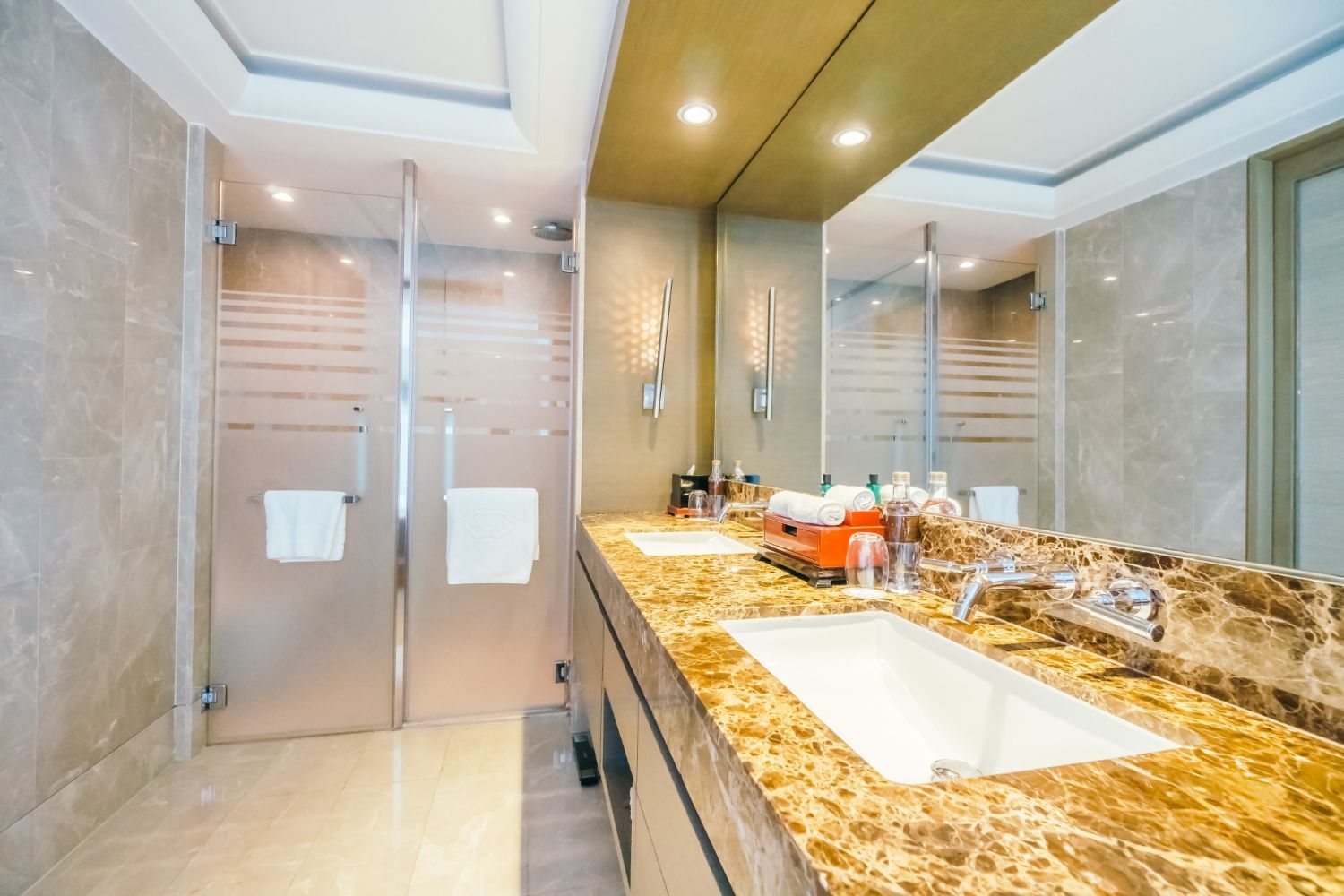 A bathroom with a sink , mirror and shower.
