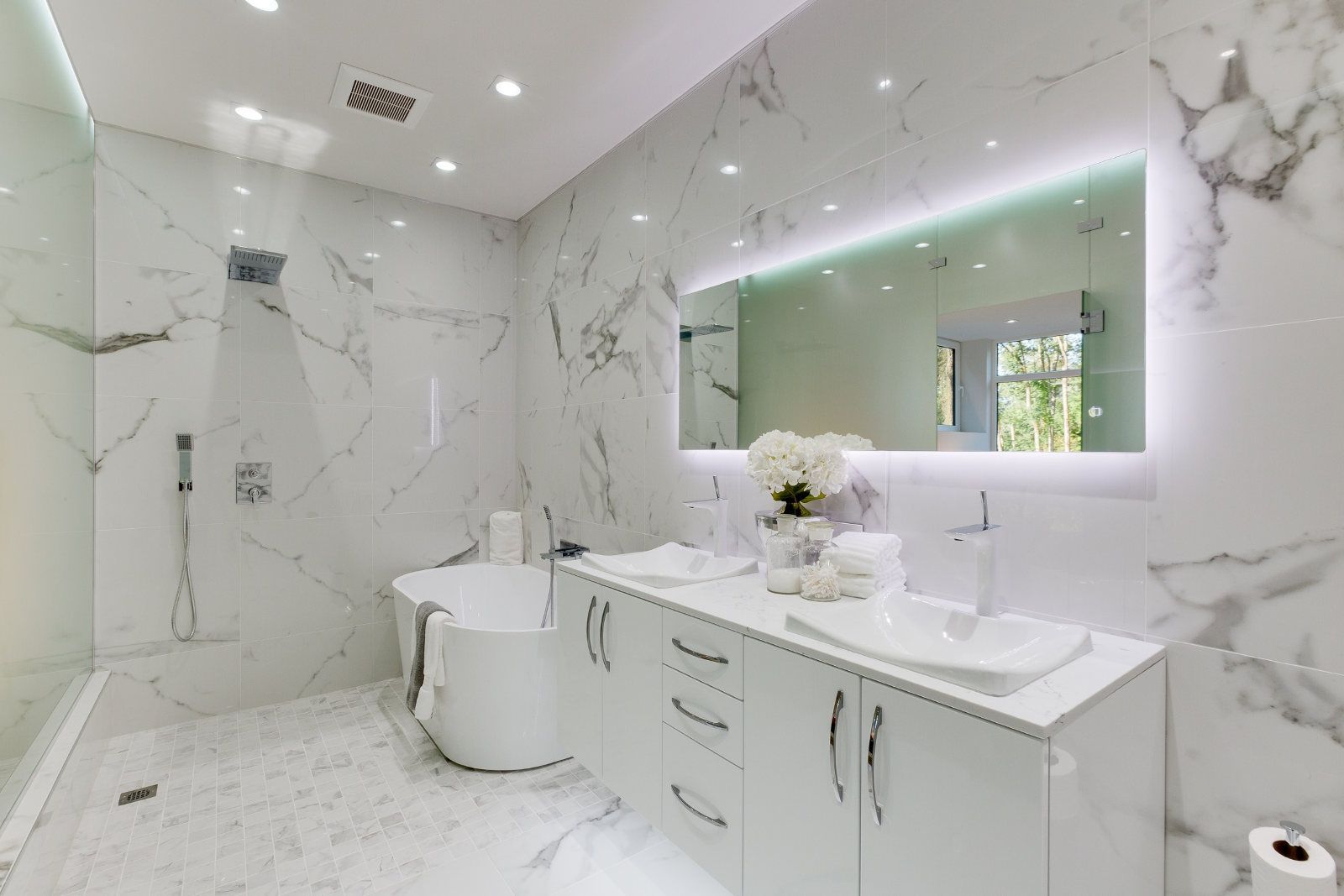 A bathroom with two sinks , a tub , a shower and a mirror.
