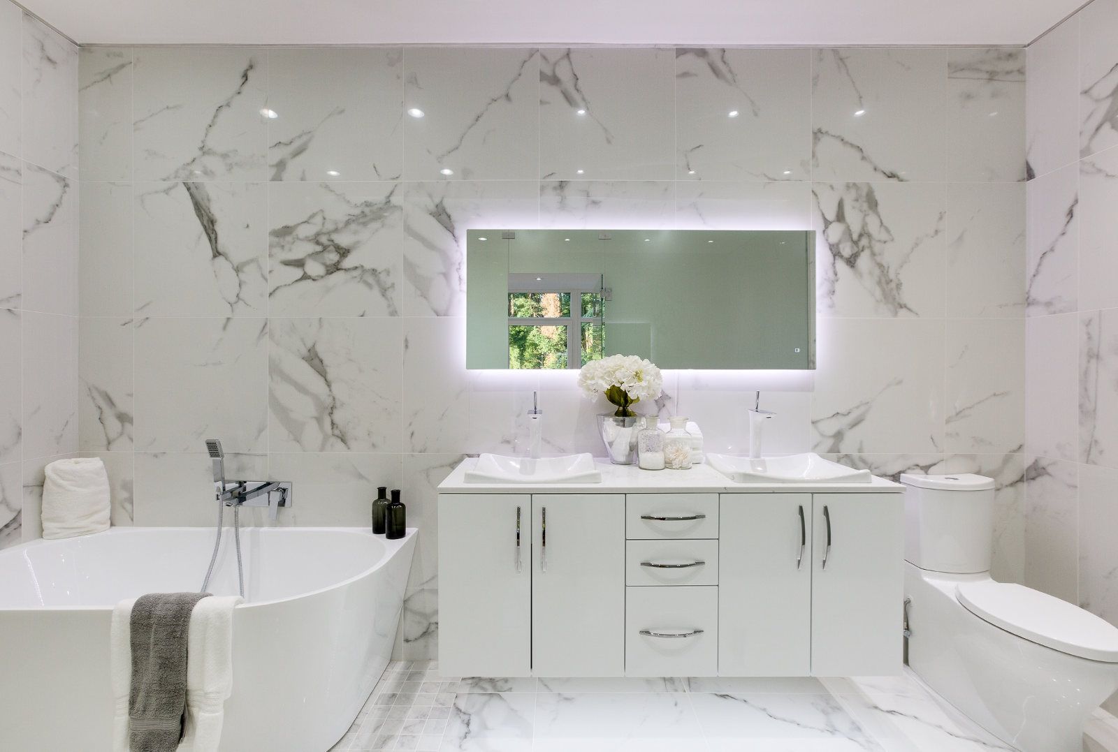 A bathroom with a bathtub , sink , toilet and mirror.