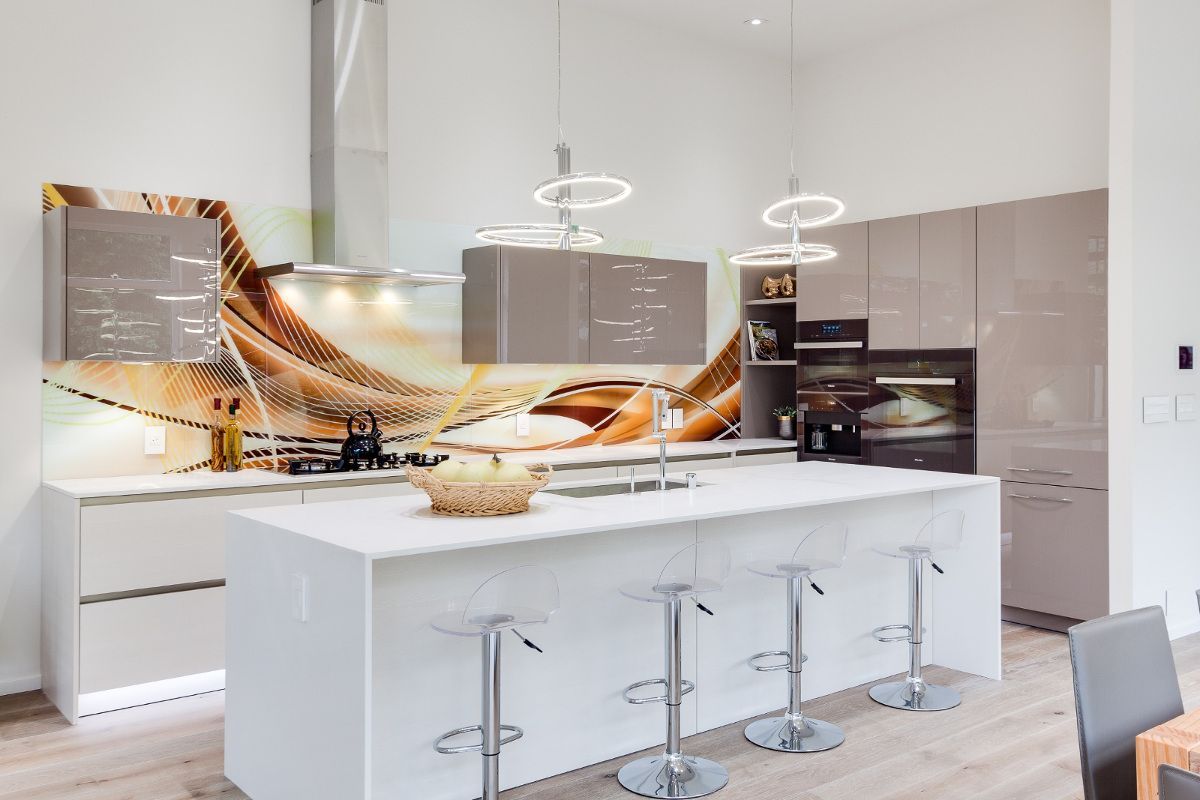 A kitchen with a large island and stools and a painting on the wall.