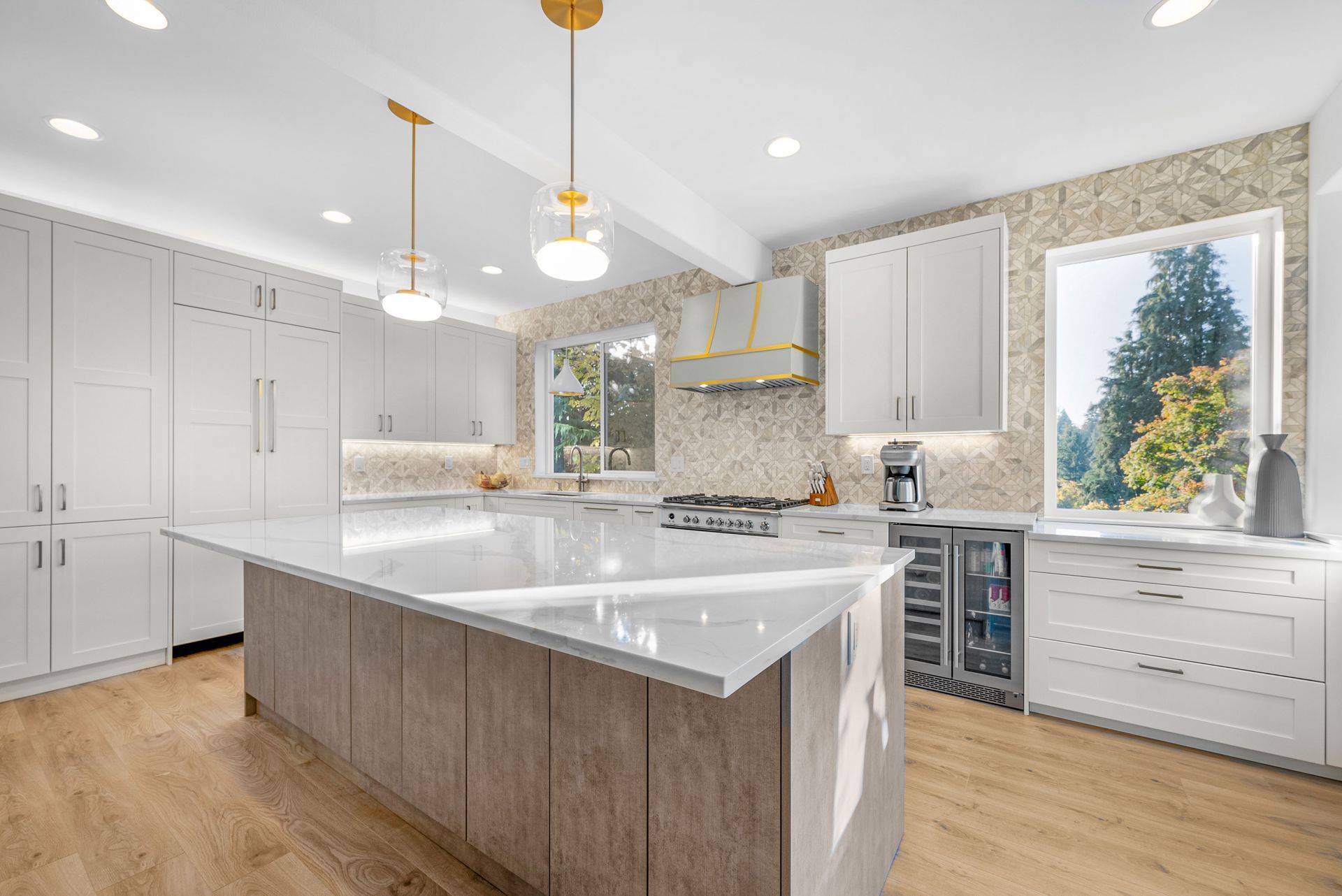 A large kitchen with white cabinets and a large island in the middle.