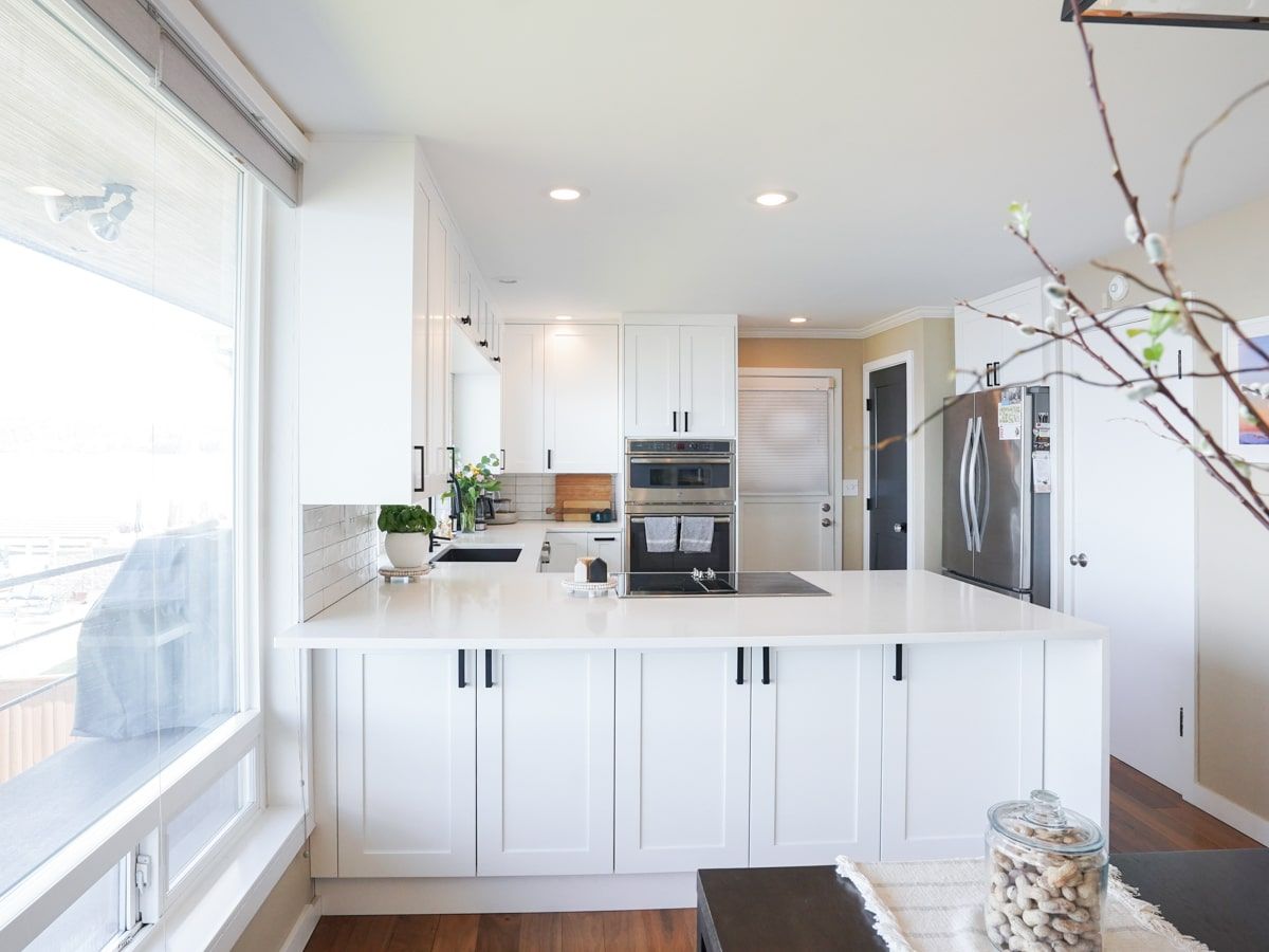 A kitchen with white cabinets and stainless steel appliances