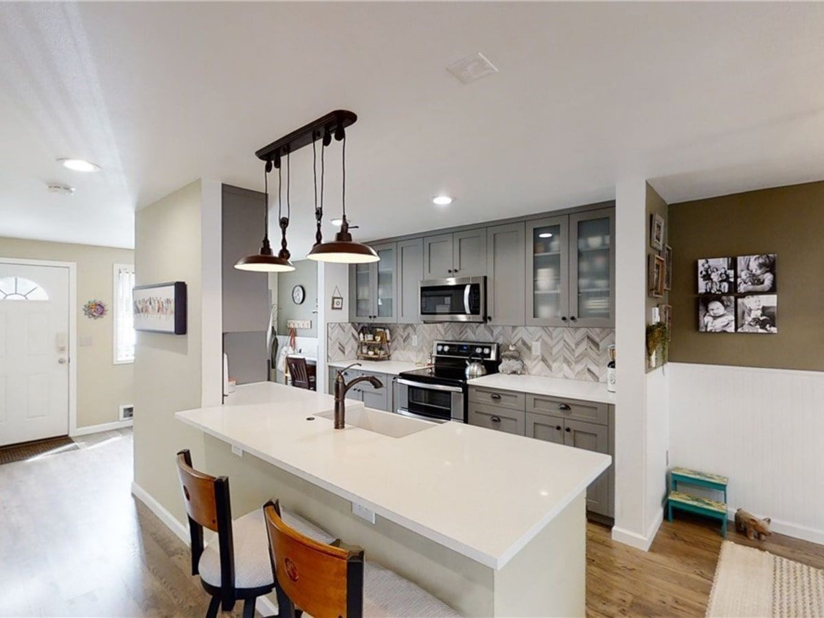 A kitchen with stainless steel appliances and a large island.
