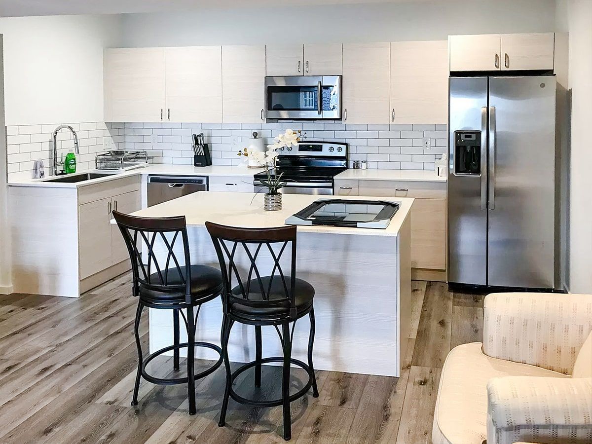 A kitchen with stainless steel appliances and white cabinets