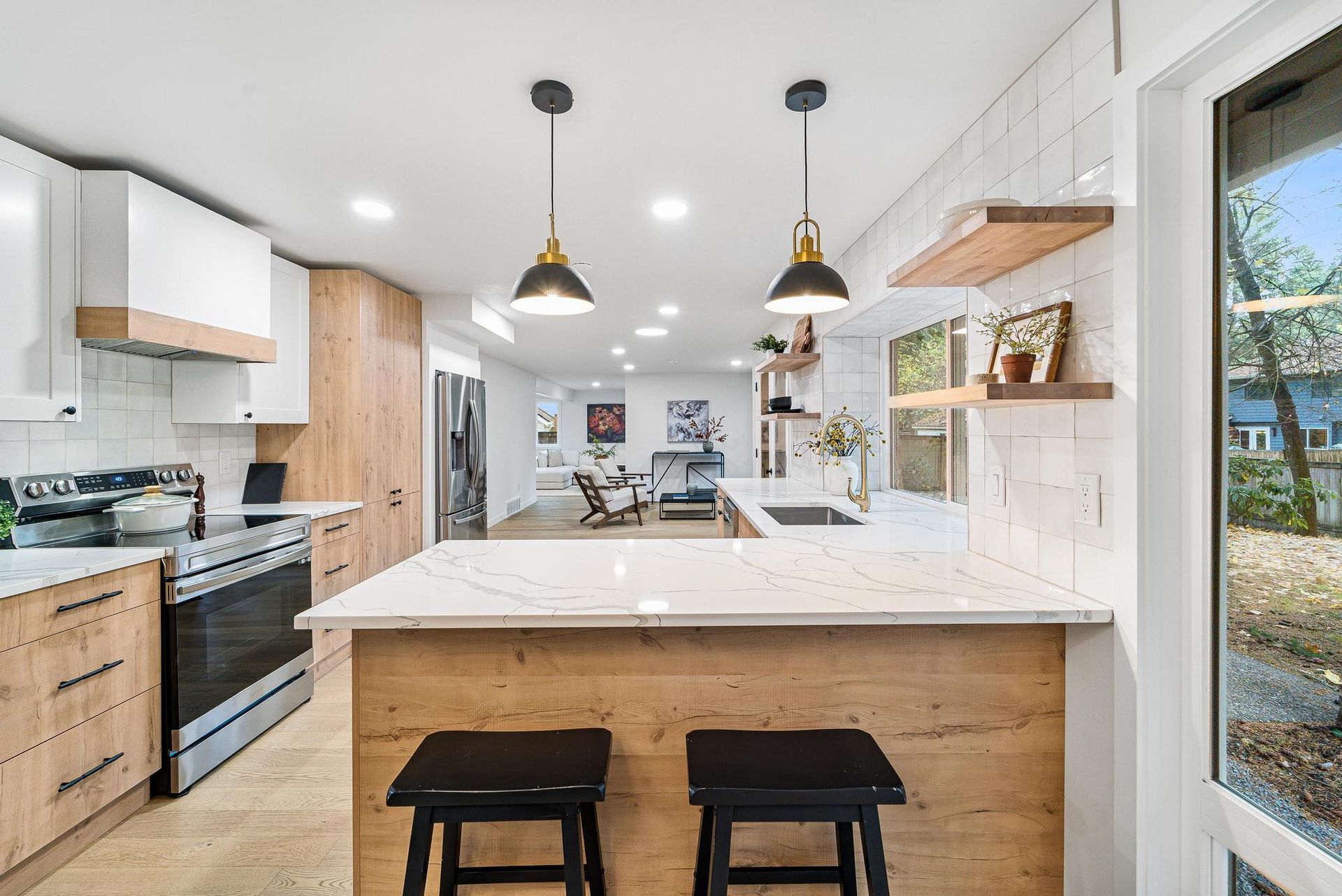 A kitchen with a large island and two stools.