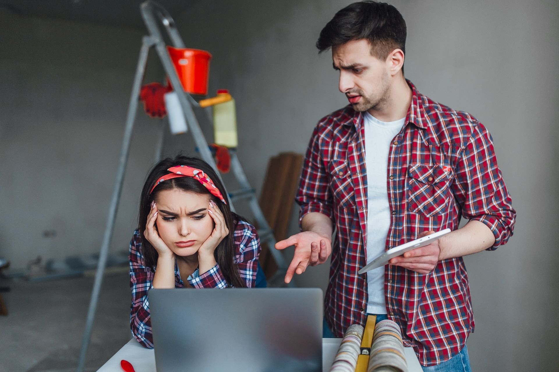 A man and a woman are looking at a laptop computer.