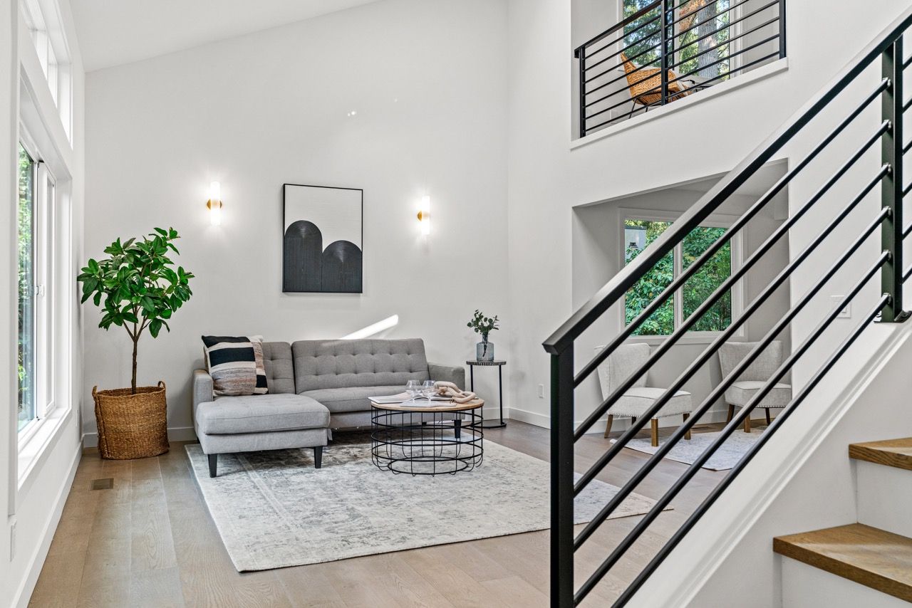 A living room with a couch and stairs leading up to the second floor.