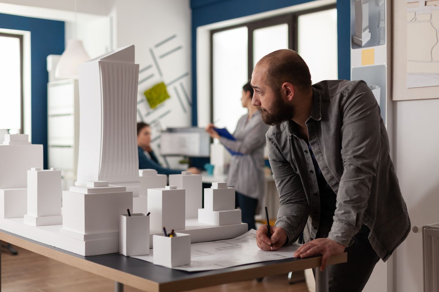 A man is standing at a table with a model of a city on it.