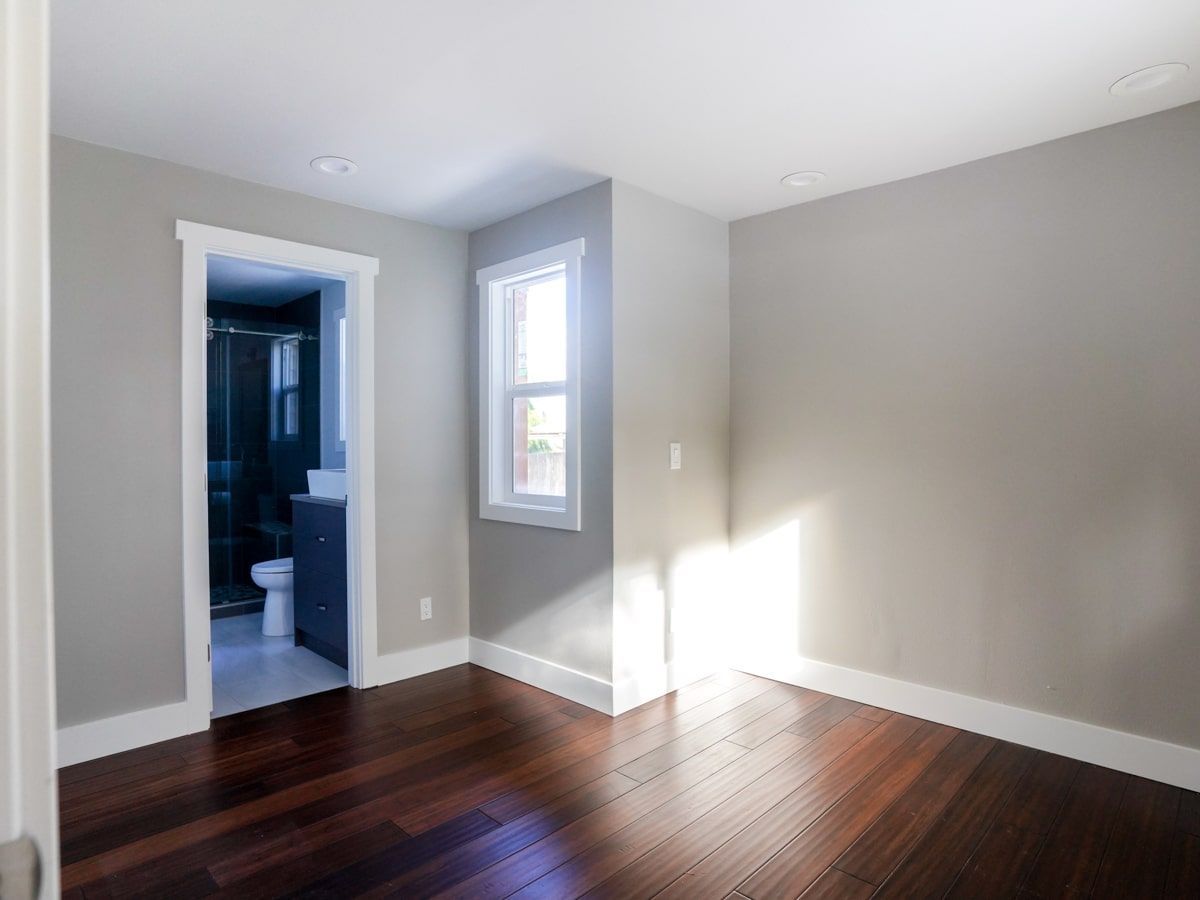 An empty room with hardwood floors and a window