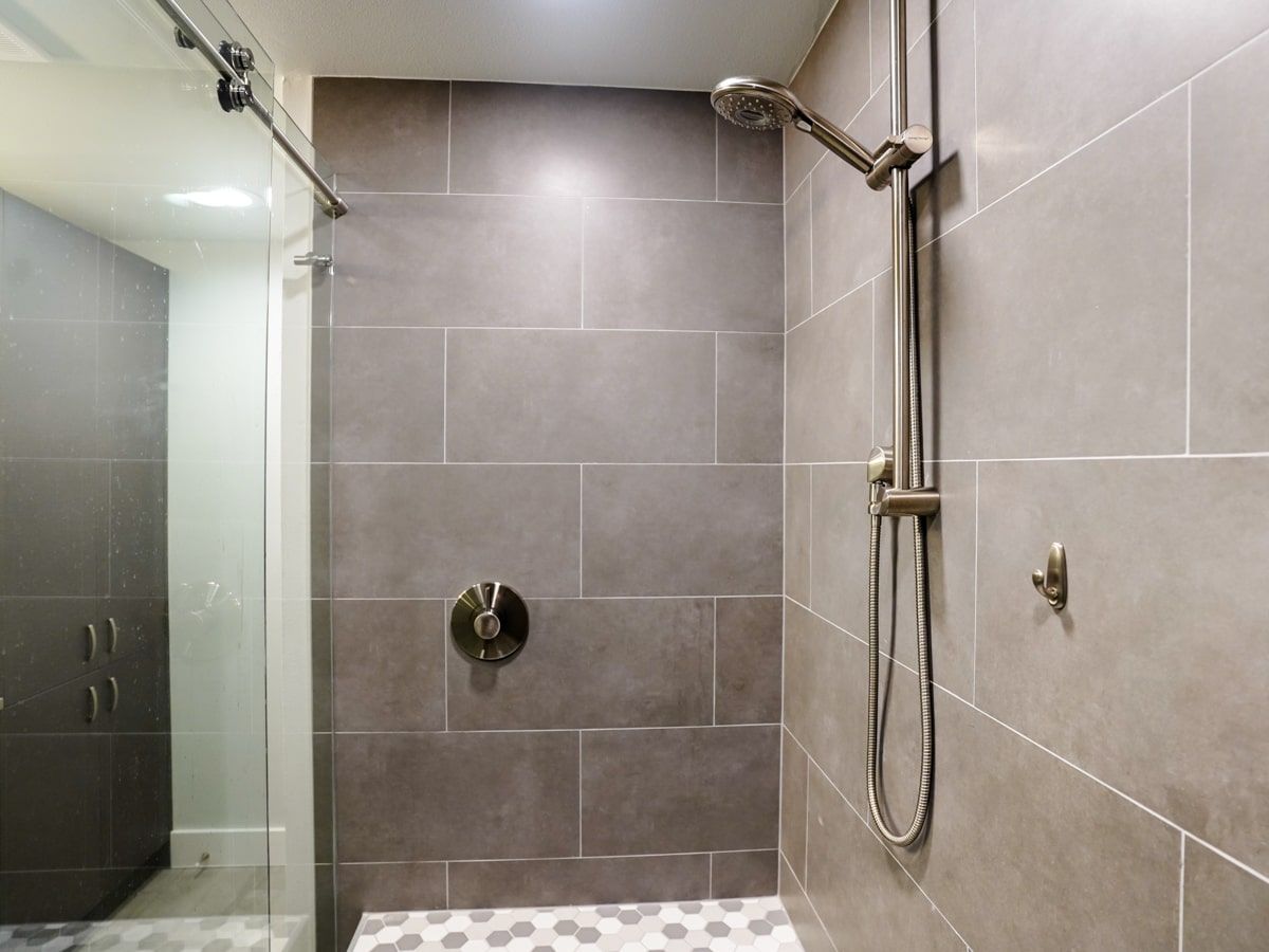 A shower with a sliding glass door and a shower head