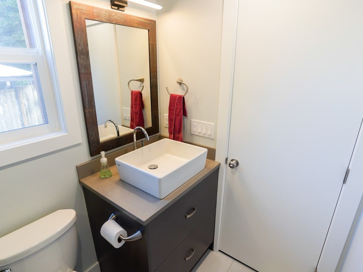 A bathroom with a sink , toilet and mirror.