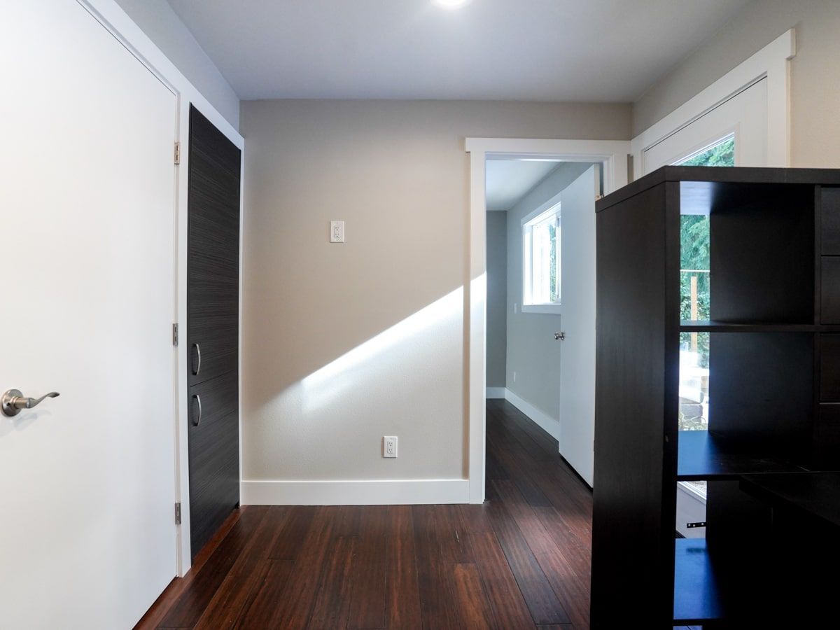 A hallway with hardwood floors and white walls
