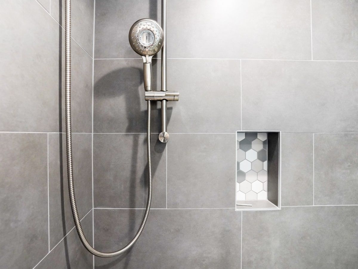A close up of a shower head in a bathroom.